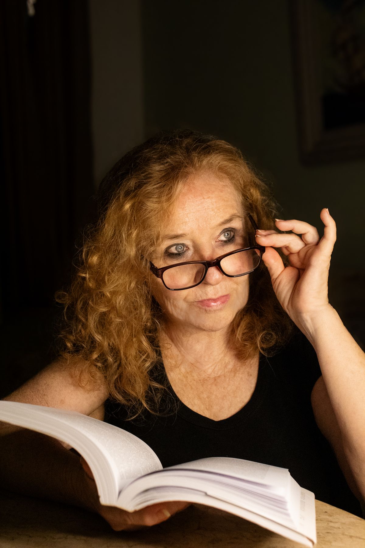 A mature woman reading at home in natural light